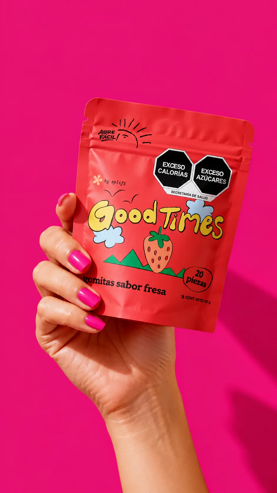 Mano sosteniendo una bolsa Good Times sobre un fondo rosa